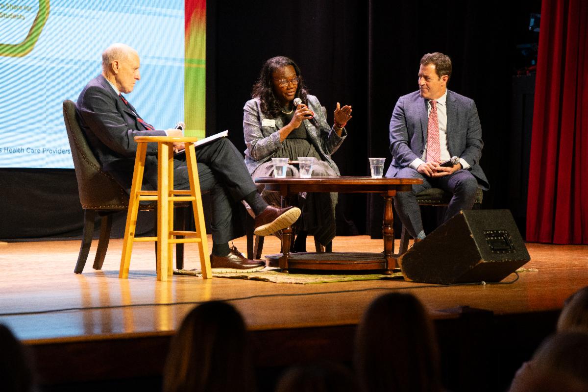 Drs. Bruce Jarrell, Yolanda Ogbolu, and Mark Gladwin are seated onstage at the Avalon Theatre in Easton, Maryland.