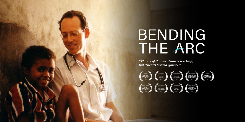 A doctor sits beside a young boy. Also includes awards won by the documentary