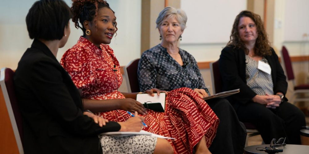 Four women sit on stage having a discussion