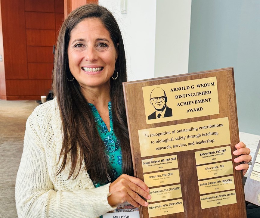 photo of Melissa Morland holding award plaque
