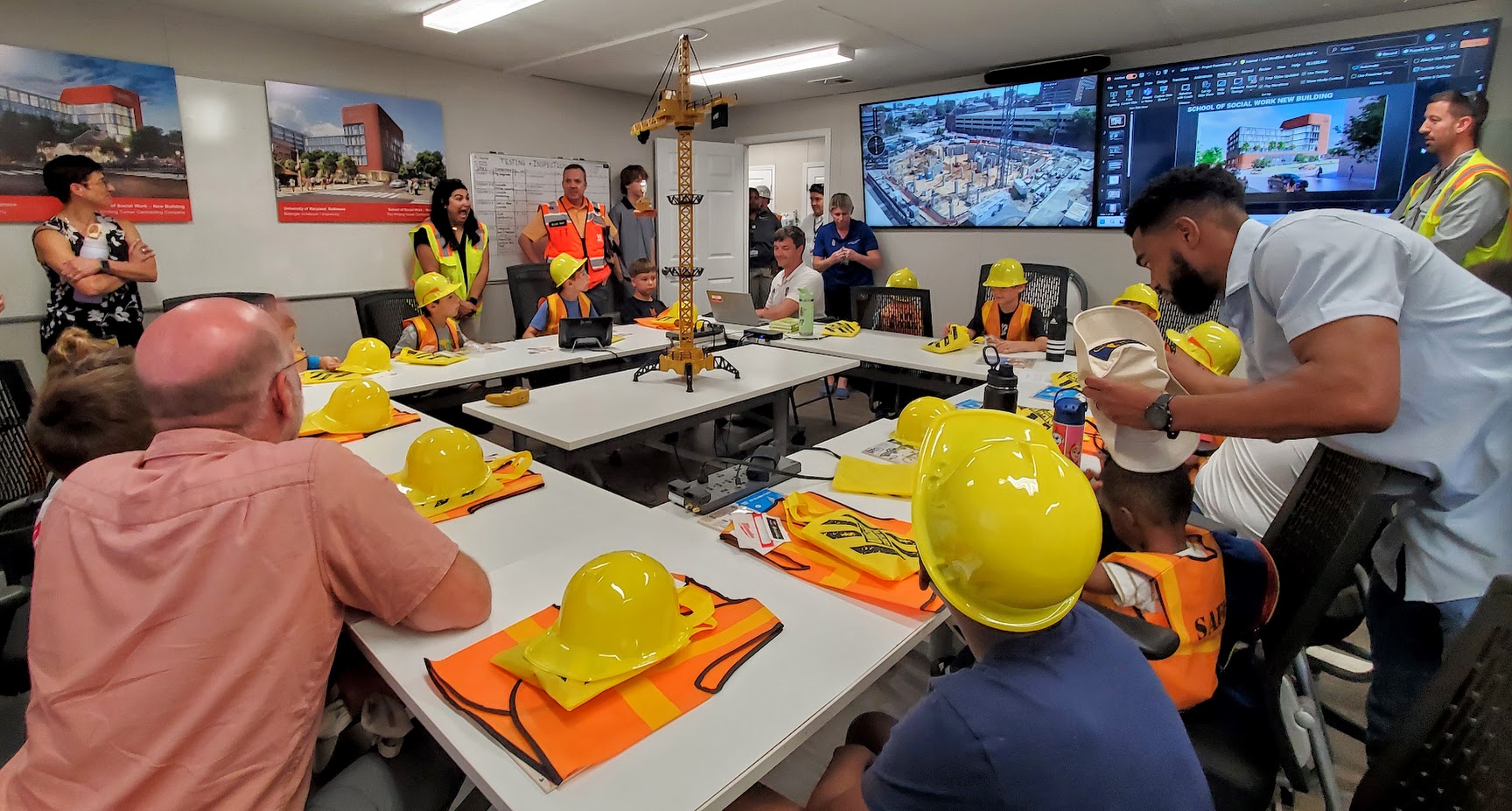 A&F children gather around a remote controlled crane for construction day