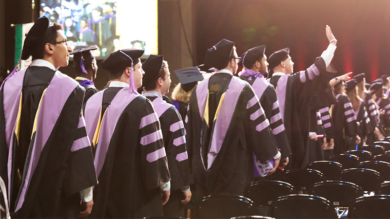 Students in graduation gowns walking for graduation