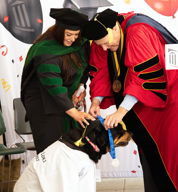 A service animal getting award for helping their companion through their degree program at UMB