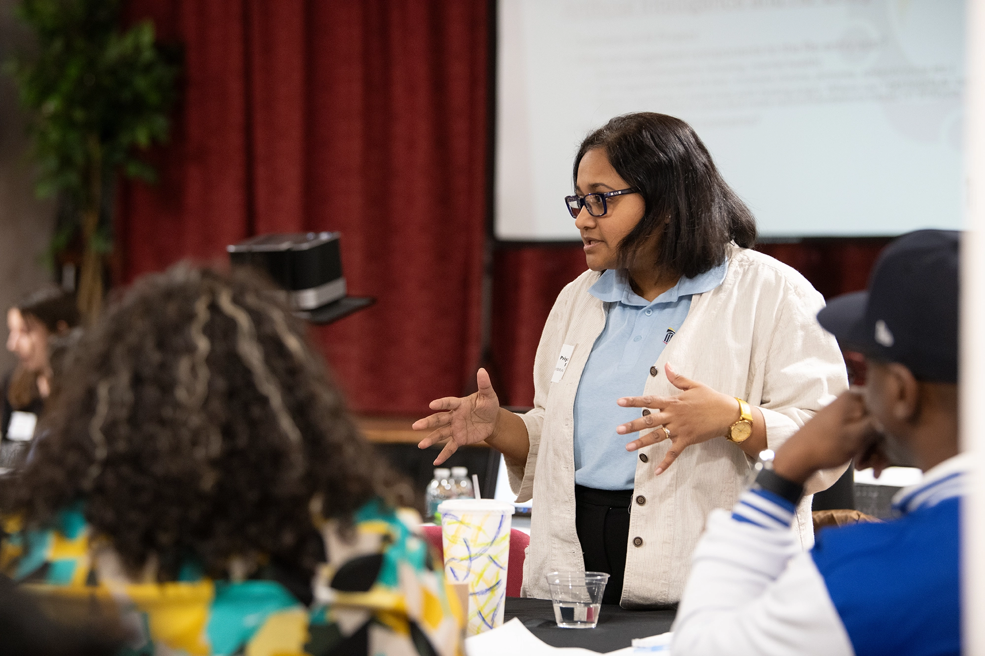An EMBRACE staff member speaking with attendees at a workshop