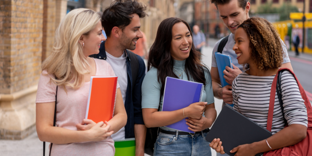 Students carrying notebooks walk and talk together