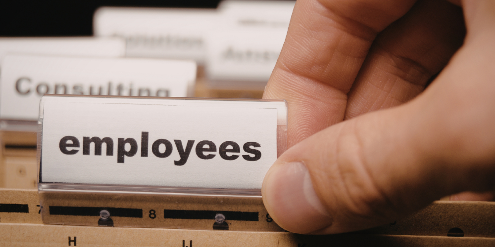 A hand grabs a tabbed folder labeled Employees
