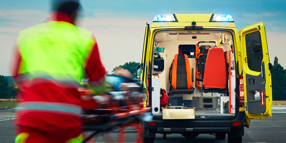 A paramedic rushes a gurney towards an open ambulance