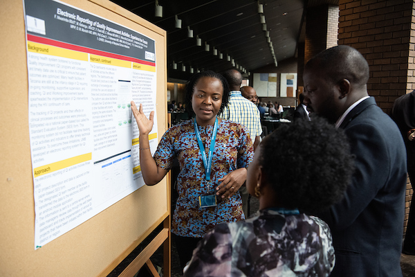 A woman explains her poster to a session attendee