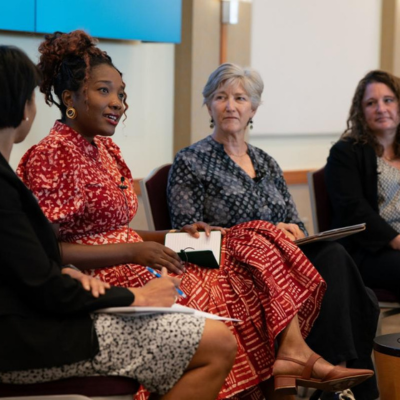 Four women speak on a stage at the convening.