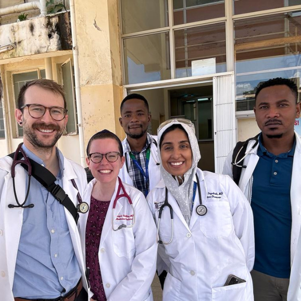 Students in medical jackets outside a building