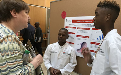 CURE mentor Malinda Hughes, chief of staff in the Office of Academic Affairs and the Graduate School, volunteers as a judge in the 2018 UMB CURE STEM Expo.