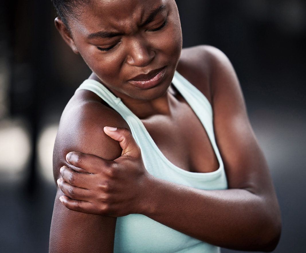 Woman holds shoulder as if in pain.