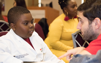 CURE Scholar Kenwan Rice listens to mentor Harrison Bell.