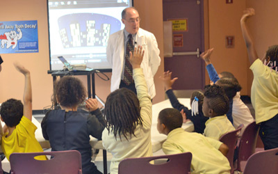 Dr. Richard Manski of the National Museum of Dentistry and the School of Dentistry works with city schoolchildren.
