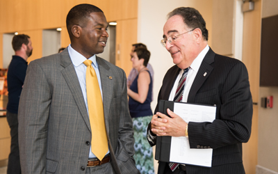 UMB President, Jay Perman, MD, (right) greets Charles Connor, aide to Sen. Chris Van Hollen, (left) ahead of the congressional delegation tour of UMB. 