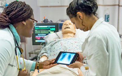 Students collaborate over a high fidelity simulated patient as part of research funded by the Center for Interprofessional Education's seed grant program.