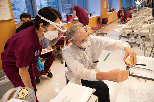 professor teaching a student dental work