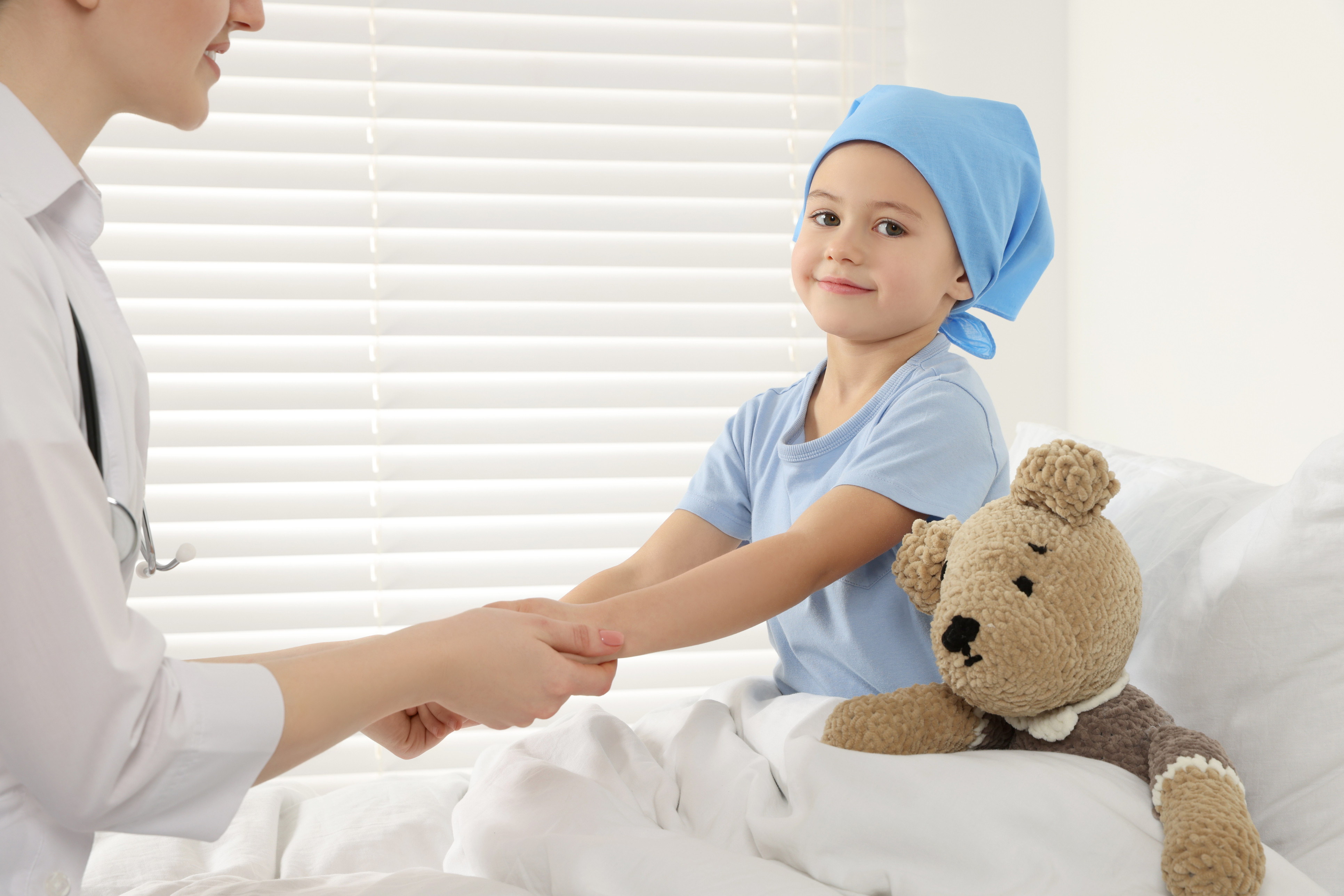 A child sitting in a bed while being treated in a hospital
